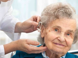 elderly women having hearing aid checked